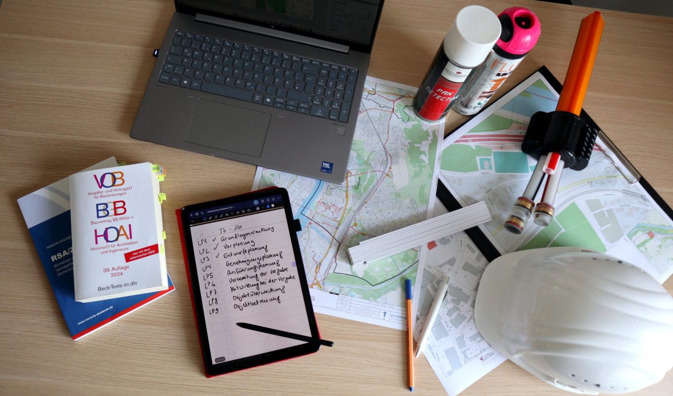 Weißer Helm auf ausgerollten Bauplänen und Technischen Zeichnungen.